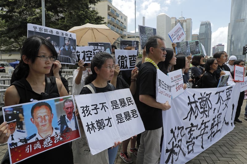 2019年6月20日,香港示威学生的父母们和宗教的各种活动团体在在警察总部外抗议,示威者举着“林郑不要杀害年轻人!”等标语。(美联社)